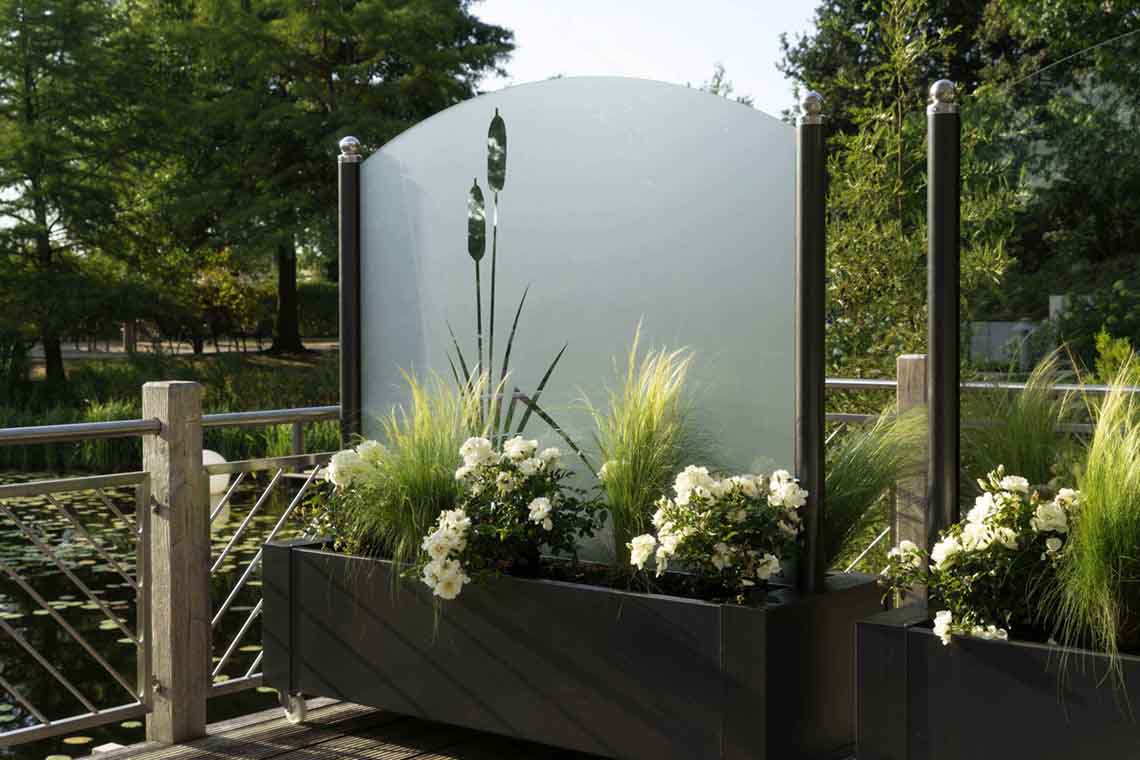 Die Glasfläche vom Wind- und Sichtschutz Flower-Line ist in diversen Formen und Dekoren erhältlich.